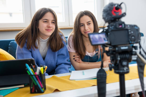 istock Teenage sisters sitting on the sofa and making a vlog after online classes 1323634217