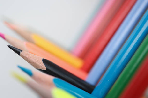 Lot of multi-colored wooden sharp pencils lying at right angles closeup background. Preschool education fine arts concept
