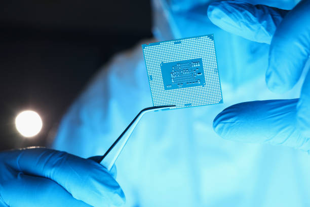 istock Repairman holding computer processor with tweezers in laboratory closeup 1323635488