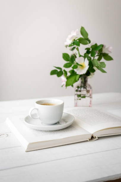 istock A white mug on an open book and flowers 1323635758