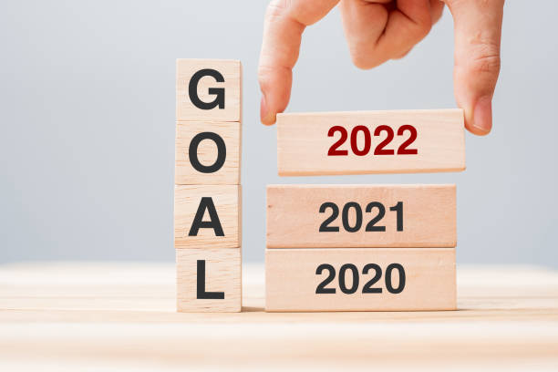 istock hand pulling 2022 block over 2021 and 2020 wooden building on table background. Business planning, Risk Management, Resolution, strategy, solution, goal, New Year New You and happy holiday concepts 1323636405