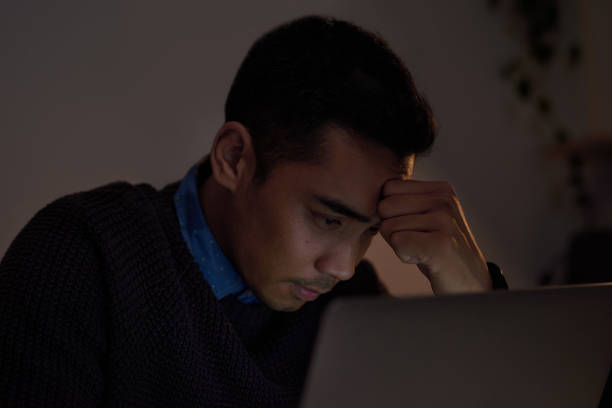 istock Shot of a young businessman looking stressed out while working late at home 1323636633