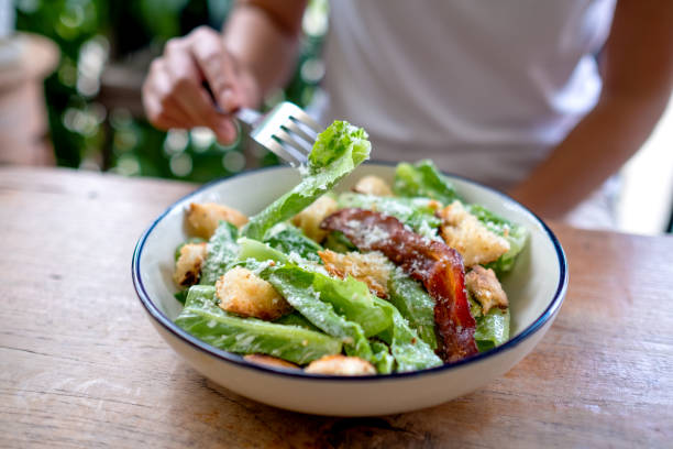 istock a woman eating a Caesar salad 1323637754
