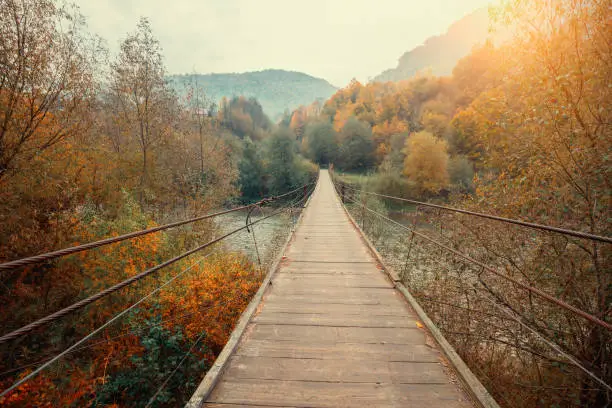 Photo of Wooden hanging rope bridge over mountain river