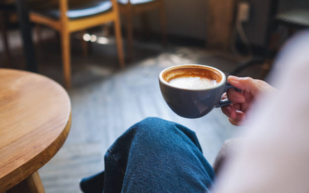istock a woman holding and drinking hot coffee 1323637893