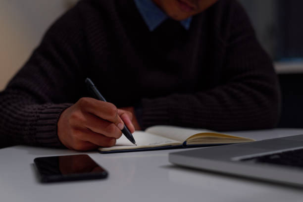 istock Cropped shot of an unrecognizable man making notes while working late at home 1323638121