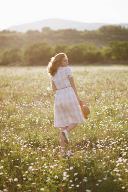 istock Young beautiful woman relaxing in chamomile field. 1323638594