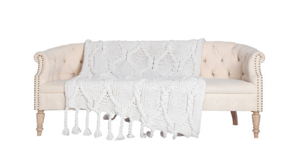 istock Beige and white sofa isolated on a white background. Soft leather armchair with a cozy white knitted blanket 1323640971