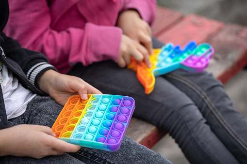 Little girls playing a new fidget toy popular with children helps them to concentrate.