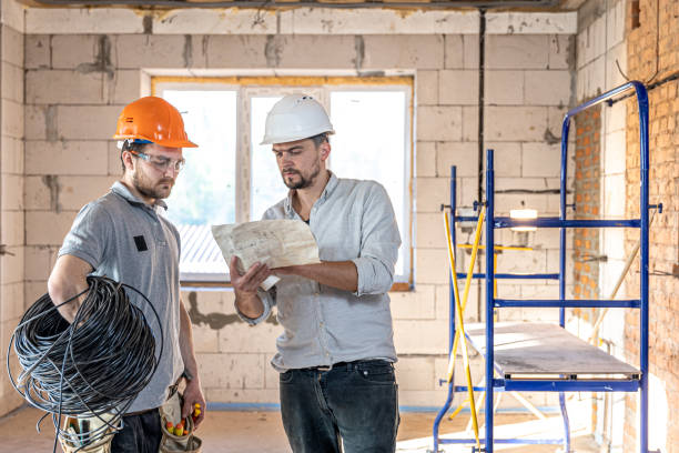 istock Two builders collaborate to build a new home. 1323643511