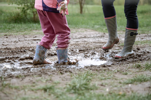 istock Children in rubber boots among the swamp. 1323643840