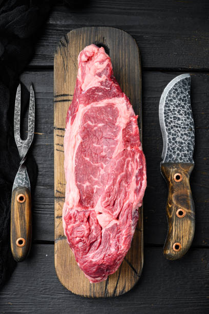 istock Rib eye beef meat cut raw, on black wooden table background, top view flat lay 1323644669
