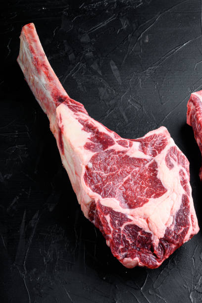 istock Barbecue Tomahawk marbled beef Steak, on black stone background, with copy space for text 1323645026