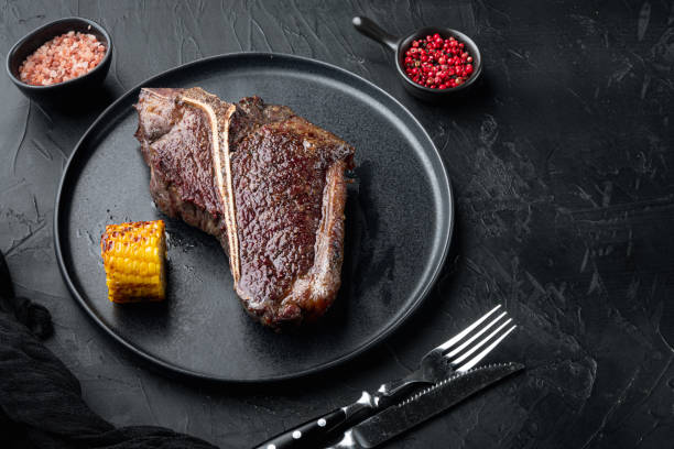 istock Aged Beef T Bone steak. Juicy cooked steak with rosemary and spices, on plate, with copy space for text 1323645372