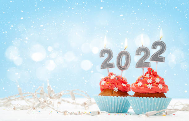 istock Christmas greeting card with cupcakes and 2022 candles 1323645909