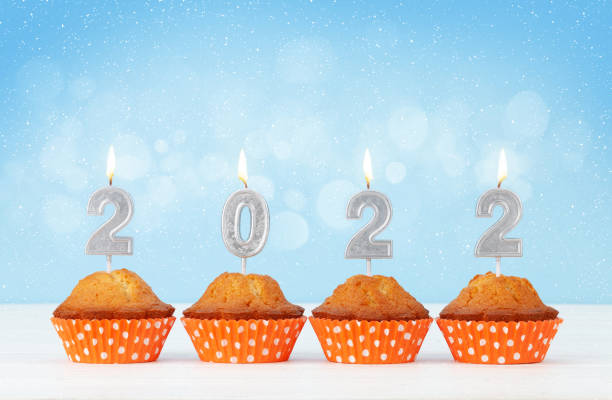 istock Christmas greeting card with cupcakes and 2022 candles 1323645941