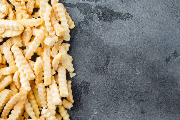 istock Frozen crinkle oven fries, on gray background, top view flat lay , with copyspace  and space for text 1323646091