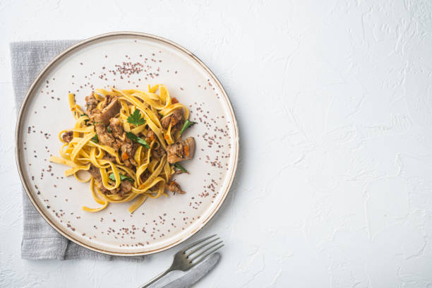 tagliatelle de guiso de conejo, en placa, sobre fondo de piedra blanca, vista superior plana lay, con espacio de copia para texto - pappardelle fotografías e imágenes de stock