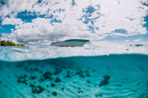 istock Tropical ocean water with sandy bottom and white boat 1323646567