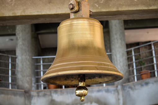 Stock photo of big ancient copper bell hanging in the temple at Kolhapur Maharashtra India.