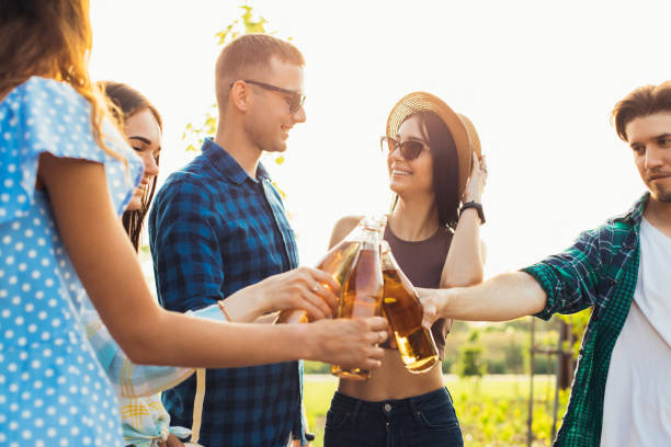istock Group of cheerful young friends having a party, having fun drinking cold drinks together, celebrating on a sunny summer 1323647889