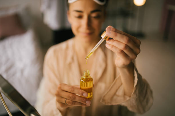 portrait of beautiful young woman holding face oil. beauty cosmetic concept. - 香精油 個照片及圖片檔