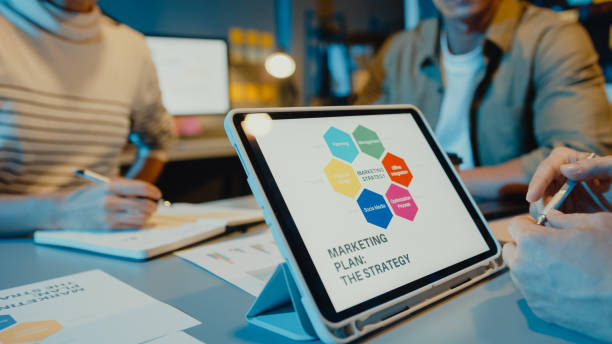 istock Asia businesspeople meeting plan analysis statistics brainstorm and header of team hold tablet point graph chart and employee take note in modern home office night. 1323649977