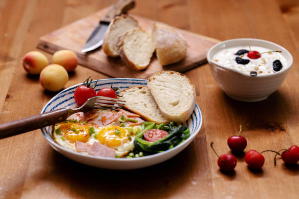 homemade breakfast: toasted bread, fried egg, ham, vegetables and fruits