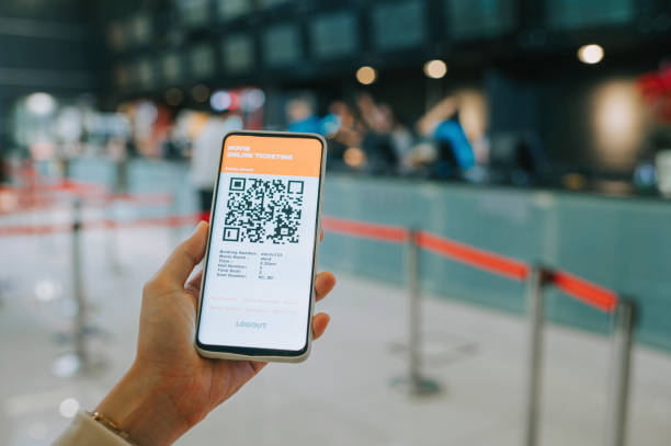 asian chinese woman using mobile app cinema movie e-ticketing reservation in front of cinema ticketing counter asian chinese woman using mobile app cinema movie e-ticketing reservation in front of cinema ticketing counter box office stock pictures, royalty-free photos & images