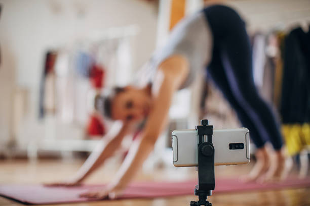 istock Female vlogging while exercising yoga 1323650271