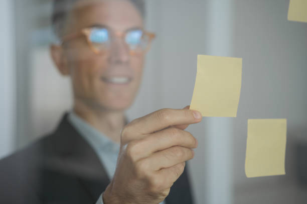 istock Confident scrum master using sticky notes, scrum for productivity. Handsome smiling businessman planning startup working with agile methodology in modern office, focus on hand 1323650287