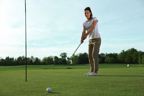 istock Beautiful woman playing golf on green course 1323651668