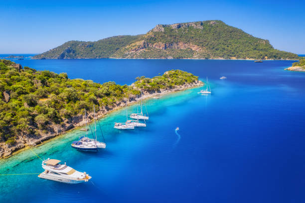 vista aérea de hermosos yates y barcos en el mar al atardecer en verano. isla gemiler en turquía. vista superior de yates de lujo, veleros, agua azul clara, playa, cielo, montaña y árboles verdes. viajar - travel luxury aerial view beach fotografías e imágenes de stock