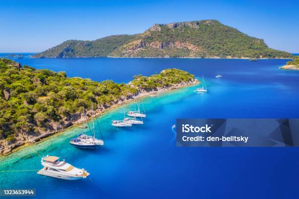 Aerial View Of Beautiful Yachts And Boats On The Sea At Sunset In Summer Gemiler Island In Turkey Top View Of Luxury Yachts Sailboats Clear Blue Water Beach Sky Mountain And Green Trees Travel Stock Photo - Download Image Now