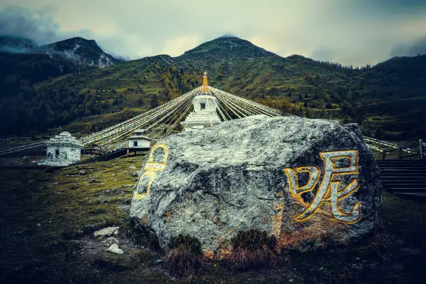 Pagodas and prayers in shuangqiaogou, Siguniangshan, Sichuan Province, China. Tibetan white pagoda prayer flags and Mani Stone