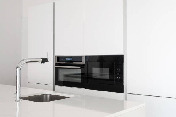 istock Minimalist kitchen with white countertop and cupboard 1323654249