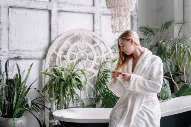 istock Young woman in bathrobe touching her hair 1323654935