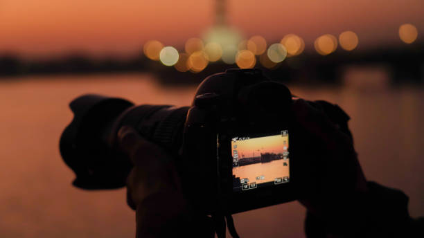 istock Silhouette of a camera capturing sunset 1323655199