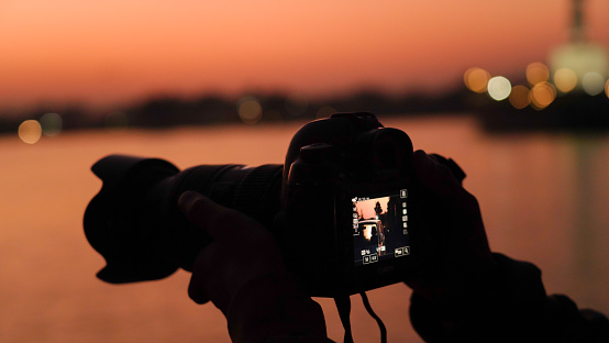 Silhouette of a camera capturing sunset
