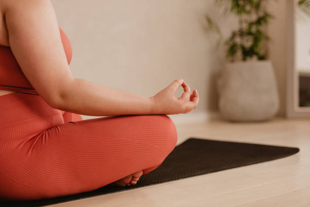 istock Woman meditating in lotus pose 1323656592
