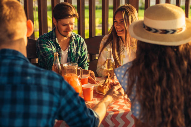 istock Young people have fun on the terrace, drink drinks and chat while their friends serve meat grilled on a barbecue outdoors 1323656665