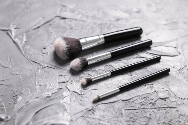 istock Top view of make-up brushes on grey background 1323659028