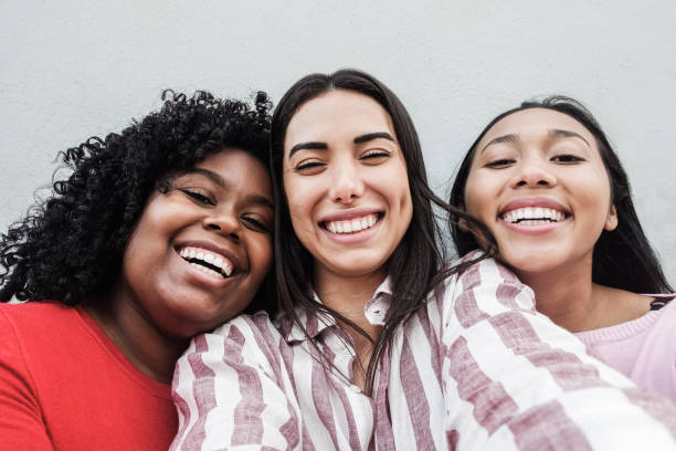 Happy latin girls having fun doing selfie together outdoor in city - Main focus on black girl face Happy latin girls having fun doing selfie together outdoor in city - Main focus on black girl face selfie girl stock pictures, royalty-free photos & images