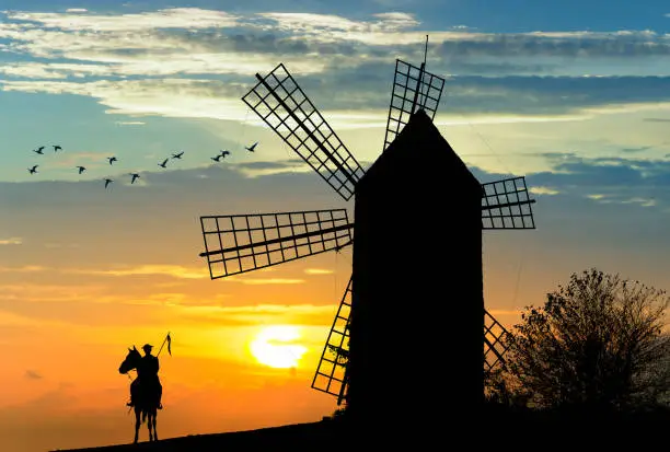 Photo of Don Quijote and Sancho Panza at the windmills in sunset