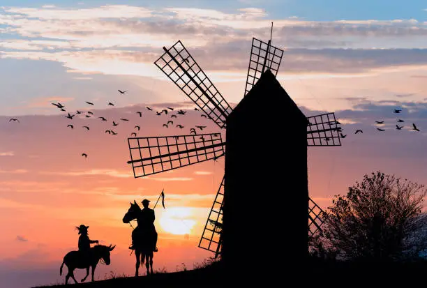 Photo of Don Quijote and Sancho Panza at the windmills in sunset