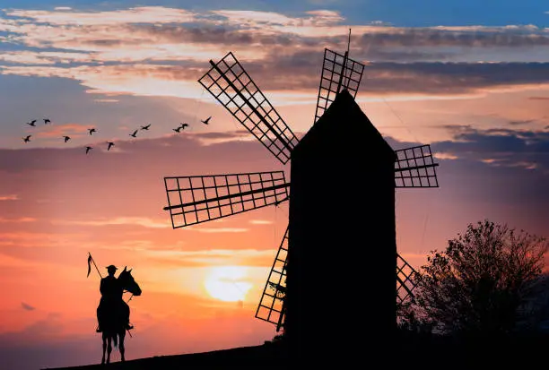 Photo of Don Quijote and Sancho Panza at the windmills in sunset