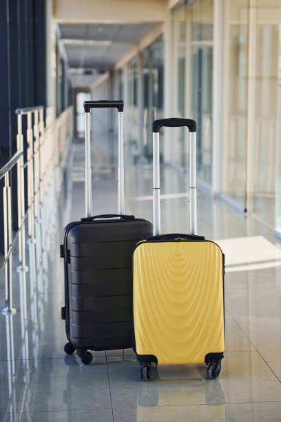 istock Black and white suitcases in airport hall at daytime 1323662321