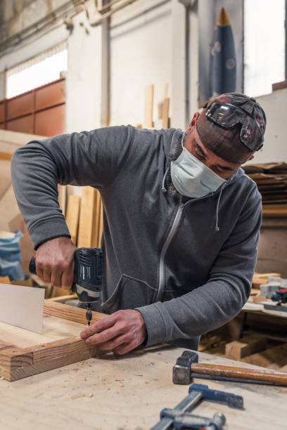istock carpenter screwing a screw with an electric screwdriver 1323665393