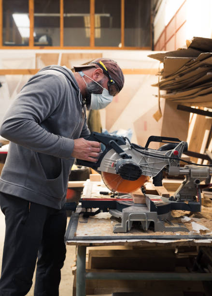 istock Carpenter cutting wood with a circular saw 1323665457