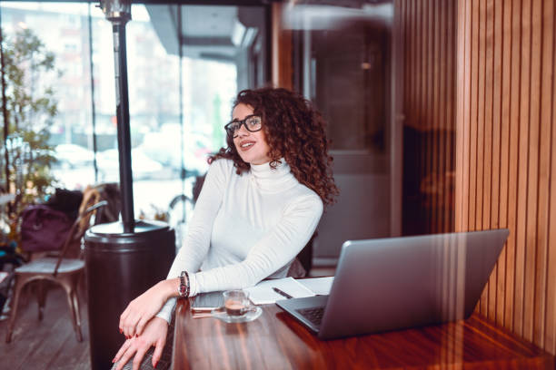 istock Beautiful Curly Female Enjoying Coffee While Finishing Work In Restaurant 1323668723